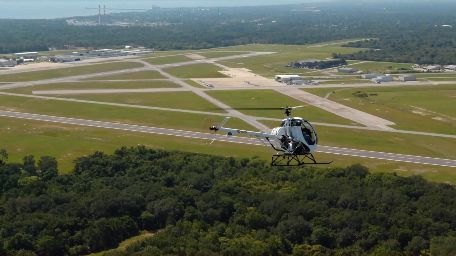 White helicopter in flight during private pilot training at USATS flight school in Florida